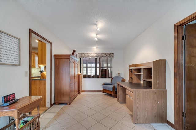 office area featuring baseboards, a textured ceiling, and light tile patterned flooring