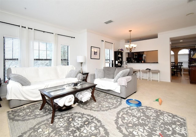 living room featuring crown molding, a wealth of natural light, light colored carpet, and a chandelier