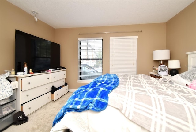 bedroom featuring light colored carpet and a textured ceiling