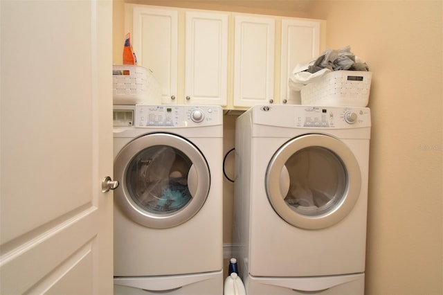 washroom featuring separate washer and dryer and cabinets