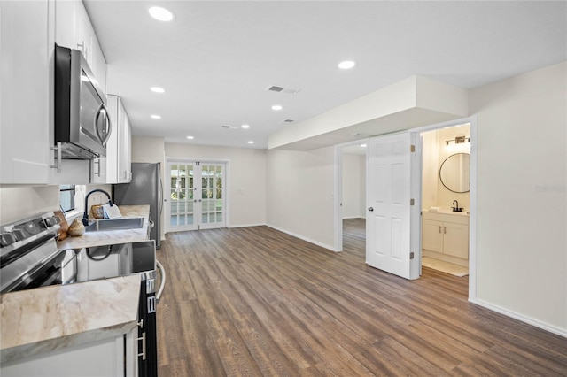 kitchen featuring dark wood-style floors, white cabinetry, stainless steel appliances, and light countertops