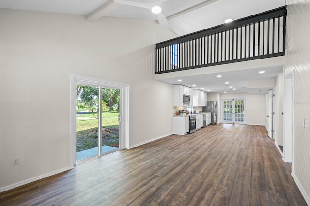 unfurnished living room featuring high vaulted ceiling, baseboards, french doors, beam ceiling, and dark wood-style floors