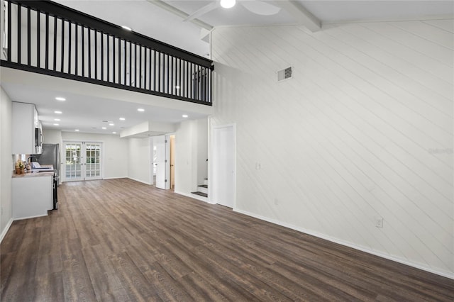 unfurnished living room featuring dark wood-style flooring, visible vents, french doors, stairway, and beamed ceiling