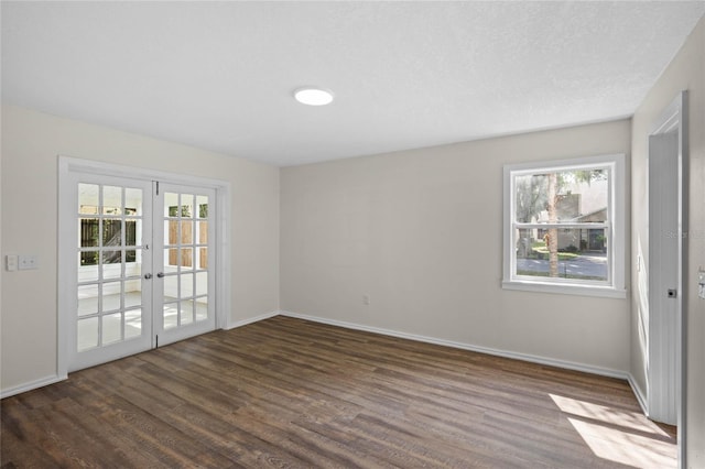 empty room featuring dark wood-style floors, french doors, and baseboards