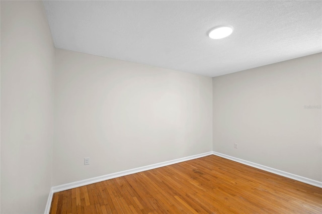 spare room with light wood finished floors and baseboards