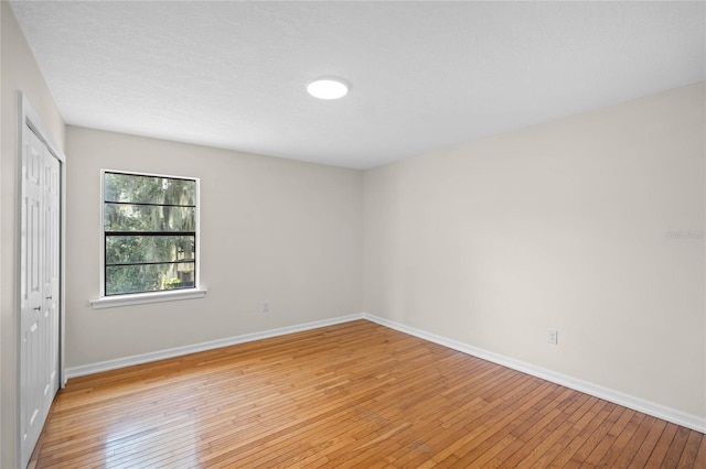 unfurnished room featuring light wood-style flooring and baseboards