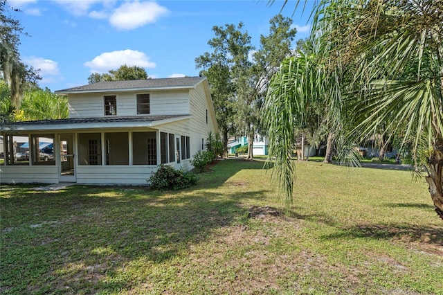 view of home's exterior featuring a lawn and a sunroom