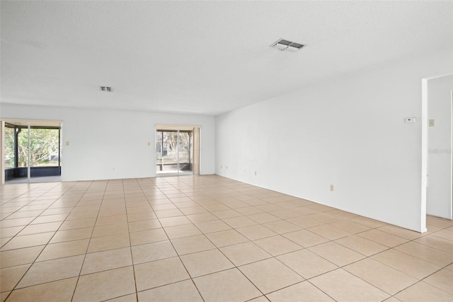 tiled spare room with a wealth of natural light and a textured ceiling