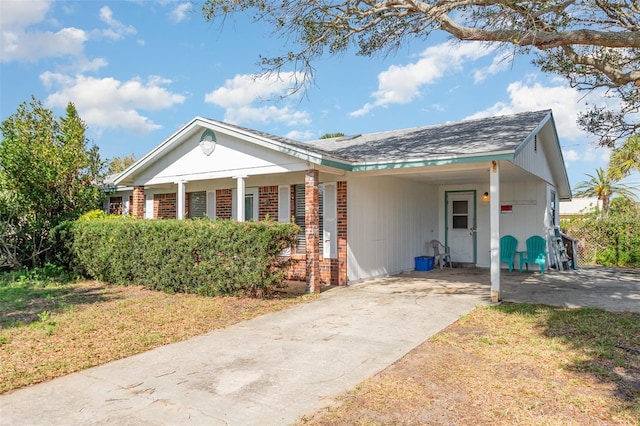 ranch-style house with a carport, a front yard, concrete driveway, and brick siding