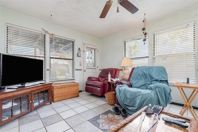 living room featuring a healthy amount of sunlight, ceiling fan, a textured ceiling, and light tile patterned floors