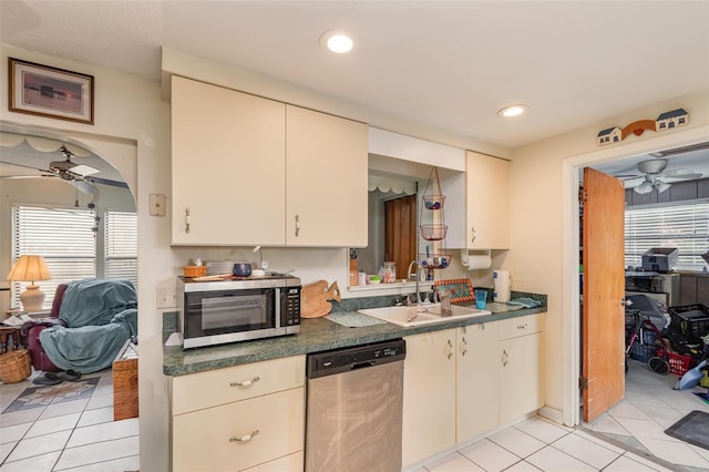 kitchen with dark countertops, ceiling fan, appliances with stainless steel finishes, and a sink