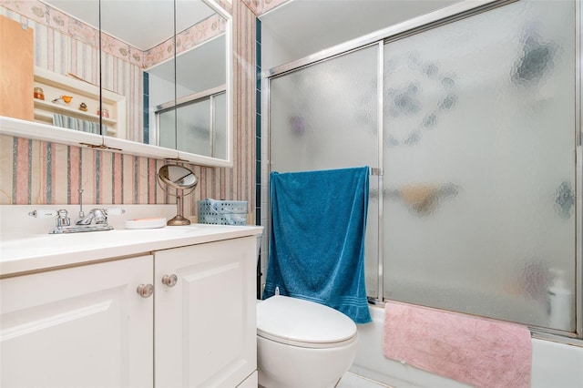 full bathroom with toilet, enclosed tub / shower combo, and vanity