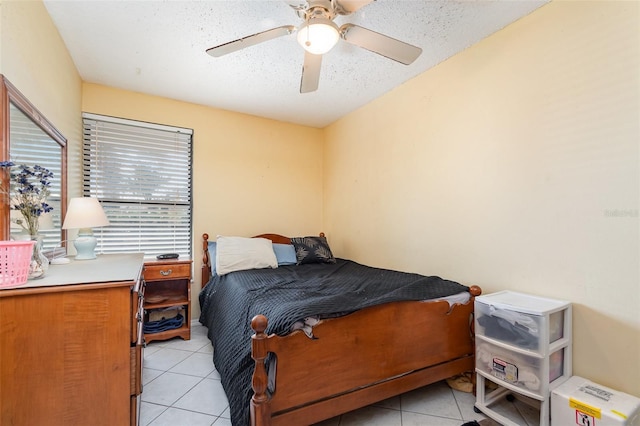 bedroom featuring light tile patterned floors, ceiling fan, and a textured ceiling