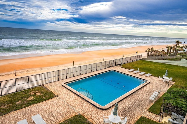 view of swimming pool with a view of the beach and a water view