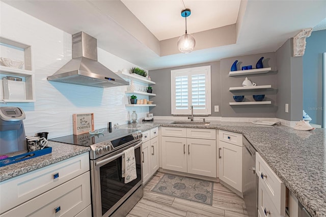 kitchen with island range hood, white cabinetry, sink, light stone counters, and stainless steel appliances