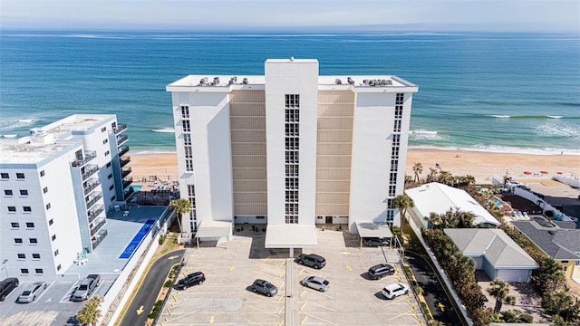 drone / aerial view with a water view and a beach view