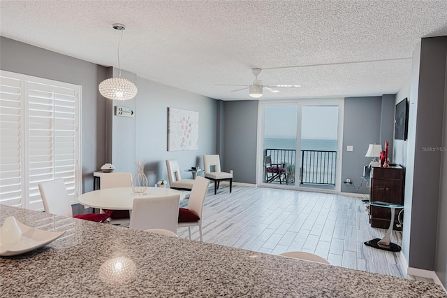 interior space featuring a water view, ceiling fan, and a textured ceiling