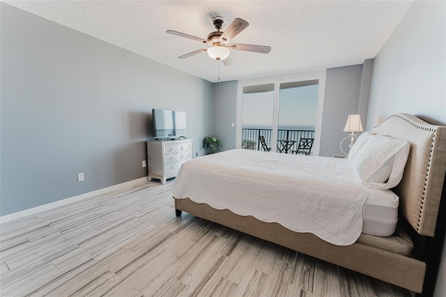 bedroom featuring ceiling fan, light hardwood / wood-style floors, and a textured ceiling