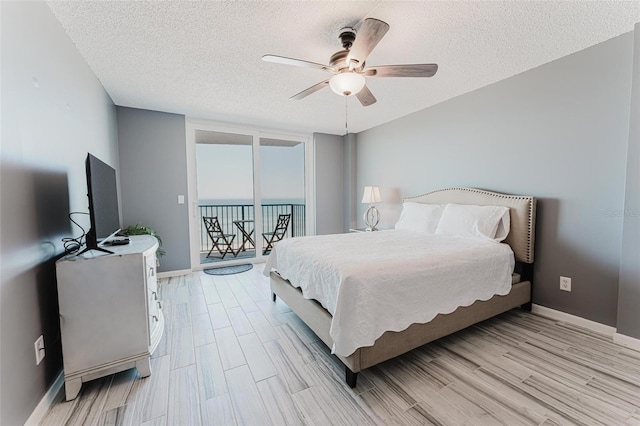 bedroom with ceiling fan, light hardwood / wood-style floors, and a textured ceiling