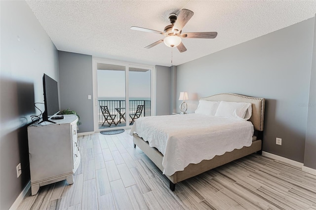 bedroom featuring ceiling fan, light hardwood / wood-style flooring, and a textured ceiling