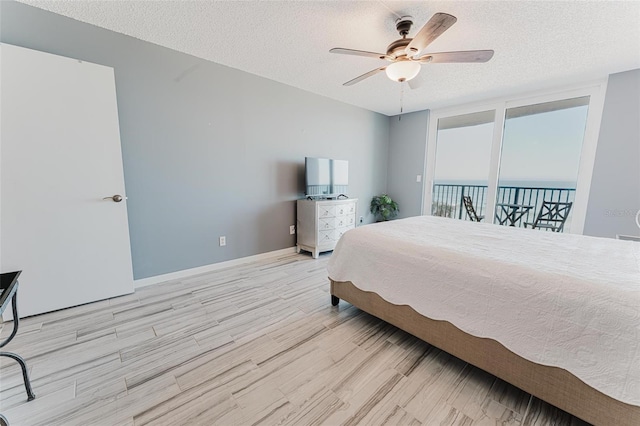 bedroom featuring ceiling fan, light hardwood / wood-style floors, and a textured ceiling