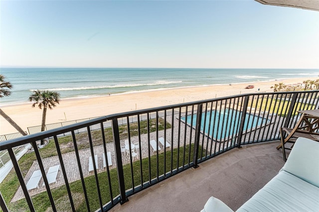 balcony with a water view and a beach view