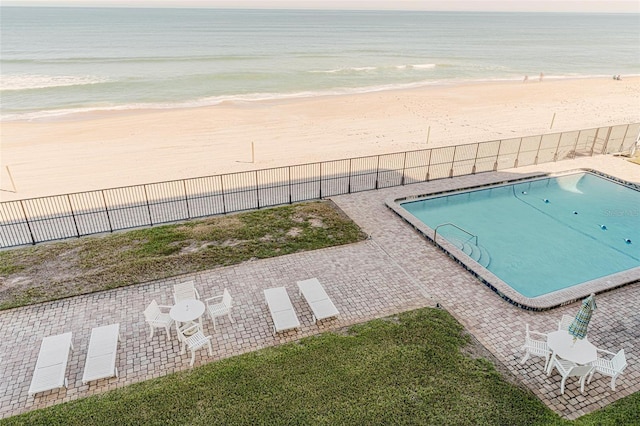 view of pool with a water view and a view of the beach