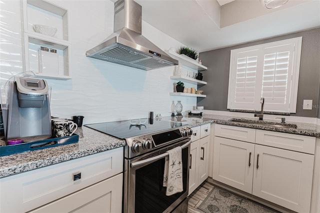 kitchen with sink, white cabinetry, island range hood, electric stove, and light stone countertops