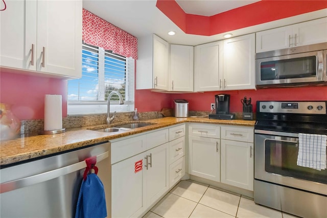 kitchen featuring white cabinetry, stainless steel appliances, sink, and light stone counters