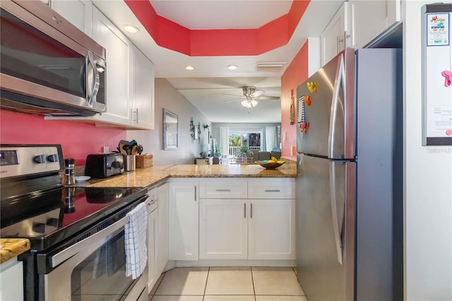 kitchen featuring light stone countertops, white cabinetry, appliances with stainless steel finishes, and light tile patterned floors