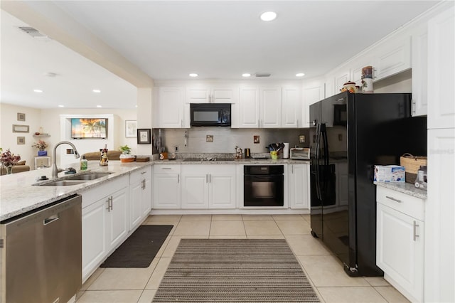 kitchen with sink, white cabinetry, light tile patterned floors, light stone countertops, and black appliances