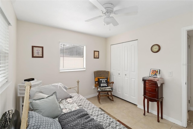 tiled bedroom featuring ceiling fan and a closet