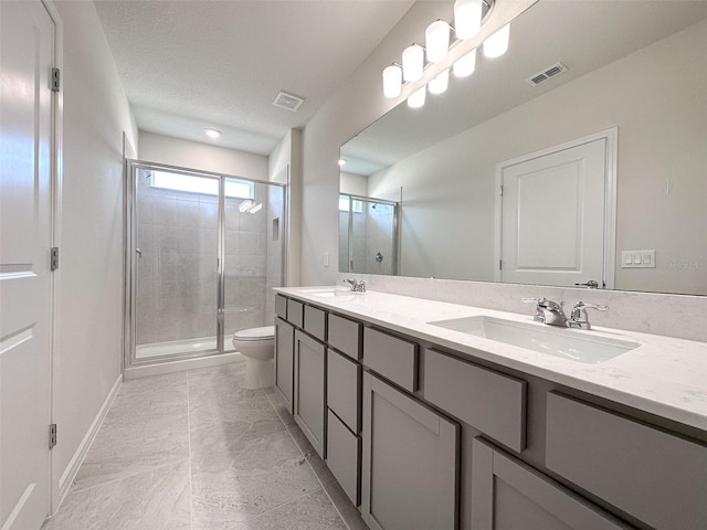 bathroom with vanity, toilet, an enclosed shower, and a textured ceiling