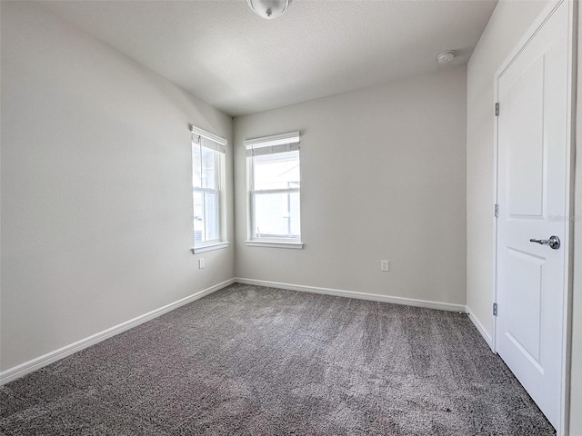 carpeted empty room with a textured ceiling