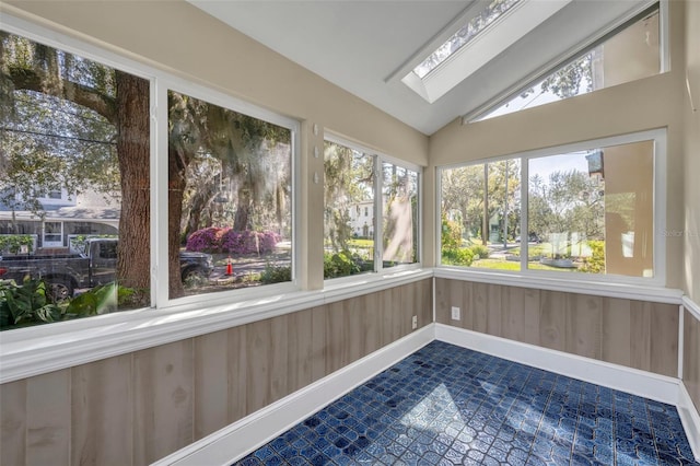 unfurnished sunroom with lofted ceiling with skylight