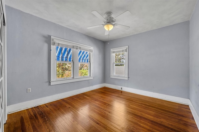 empty room featuring ceiling fan, baseboards, and hardwood / wood-style flooring