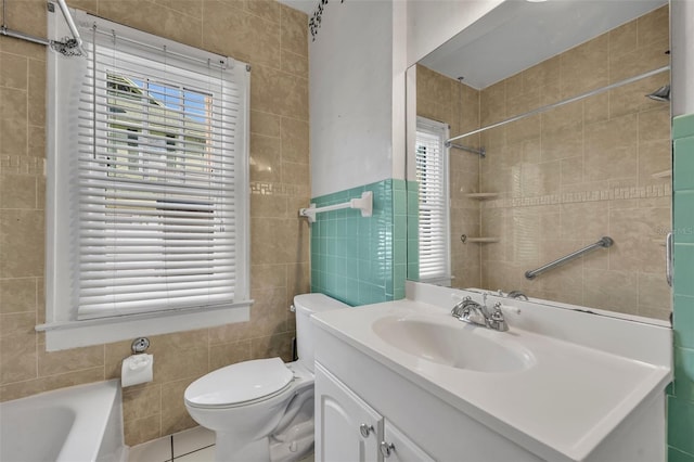 full bath featuring tile walls, toilet, vanity, a tub, and tile patterned floors