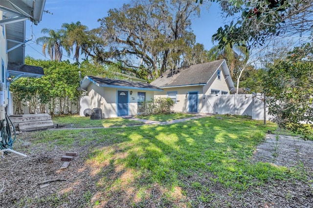 view of front of home with a front lawn, a fenced backyard, and stucco siding