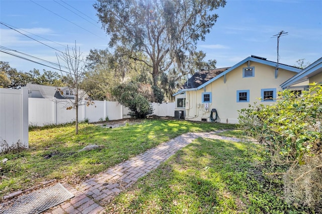 view of yard with a fenced backyard and central AC unit