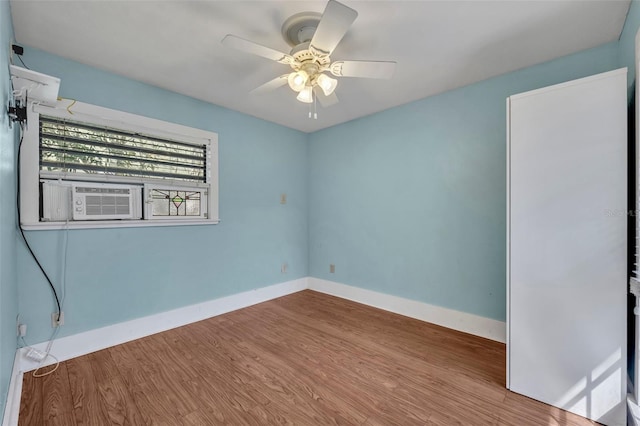 spare room featuring a ceiling fan, baseboards, and wood finished floors