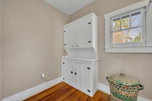 clothes washing area with wood finished floors