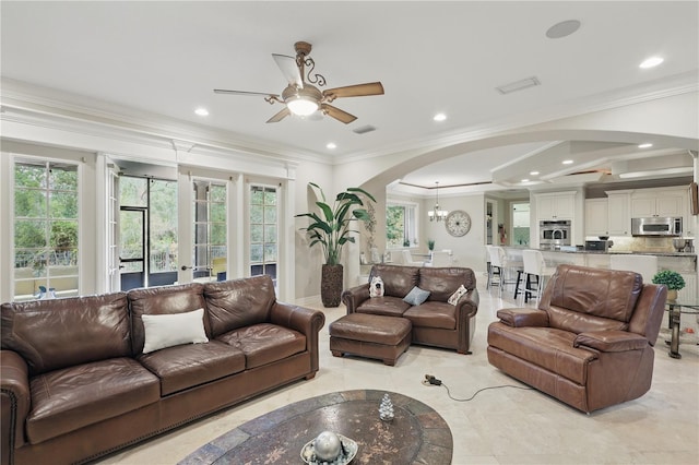 living area with visible vents, arched walkways, crown molding, and recessed lighting