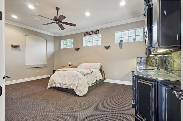 bedroom with baseboards, a sink, visible vents, and crown molding