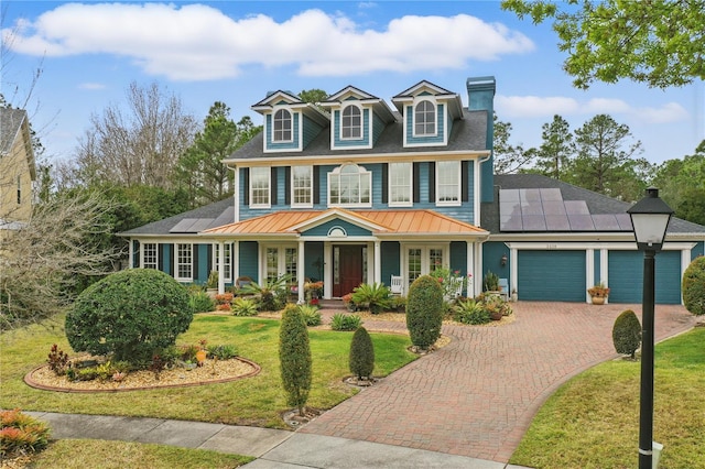 view of front facade featuring a garage, a porch, decorative driveway, and roof mounted solar panels