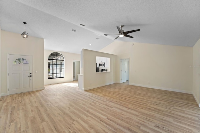 unfurnished living room featuring vaulted ceiling, ceiling fan, light hardwood / wood-style floors, and a textured ceiling