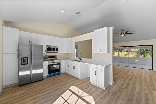 kitchen with sink, vaulted ceiling, stainless steel appliances, light hardwood / wood-style floors, and white cabinets