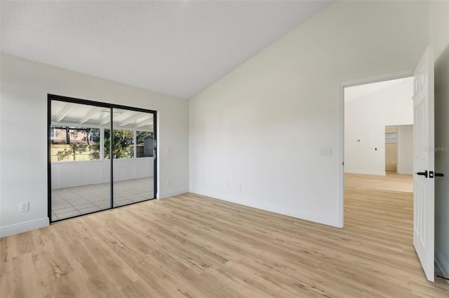 empty room featuring vaulted ceiling and light wood-type flooring