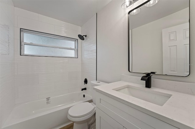 full bathroom with tiled shower / bath, vanity, and toilet