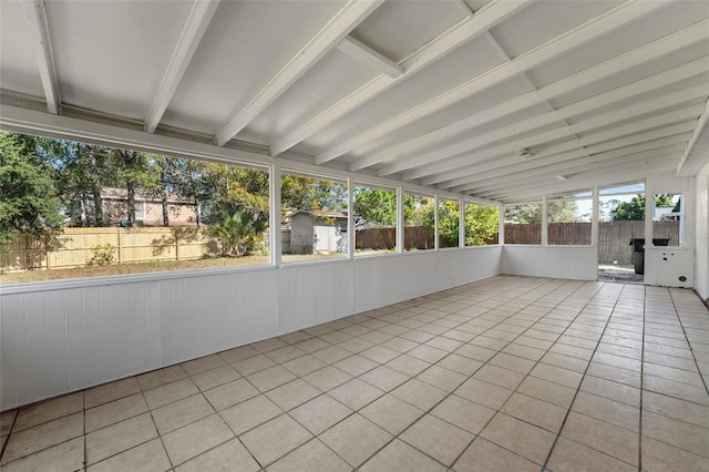 unfurnished sunroom with lofted ceiling with beams and a wealth of natural light