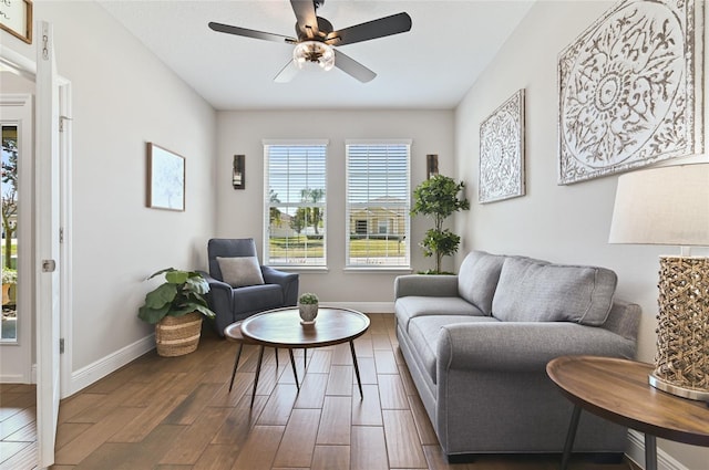 living area featuring dark hardwood / wood-style flooring and ceiling fan